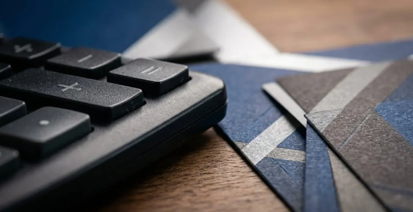 Calculatrice et documents financiers sur un bureau, symbolisant le calcul du budget de crise en cas d'invalidité pour un TNS.